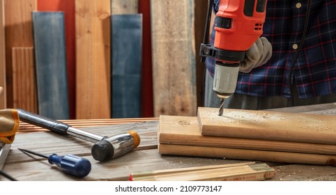 Drill Electric Tool, Carpenter Hand Drilling Wooden Plank. Construction Industry, Work Bench Table Closeup View