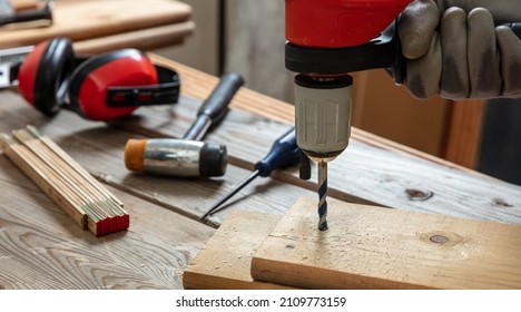 Drill Electric Tool, Carpenter Hand Drilling Wooden Plank. Construction Industry, Work Bench Table Closeup View