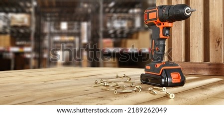 Drill on wooden table and workshop interior. 