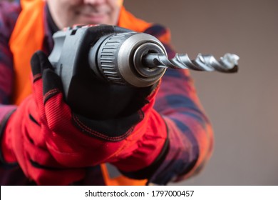 Driller. Man brings a electric drill to the camera. Worker wants to drill a camera. Concept - man is drilling a screen. Borer drills are very close to the screen. Concept - purchase of a drill.
