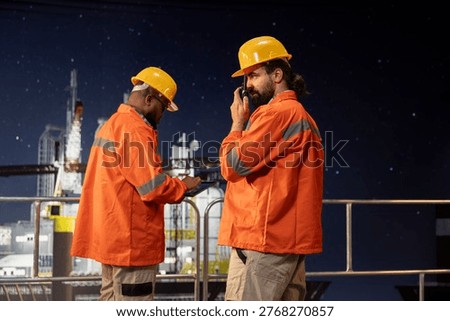 Drilling barge engineer using two way radio to coordinate emergency response procedures. Offshore platform worker facilitating quick communication with technical team during late shift operations