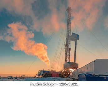 Drilling A Deep Well With A Drilling Rig In An Oil And Gas Field. The Field Is Located In The Far North Beyond The Arctic Circle. Beautiful Dramatic Sky Of The Polar Day.