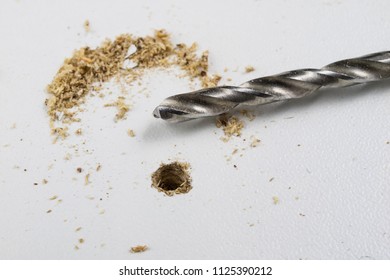 Drilling holes in chipboard. Joinery accessories used in the construction of furniture. Light background.