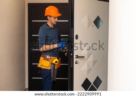 Drilling and installation of interior doors, the craftsman makes a hole in the door frame with a hand drill, doors and installation