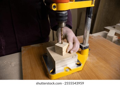 Drilling machine working on a cube-shaped wood piece in a carpentry workshop, highlighting woodworking, precision, and craftsmanship. - Powered by Shutterstock