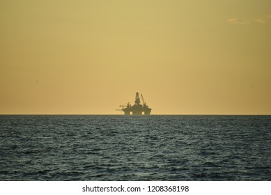 Drilling Platform In The Ocean. High Yellow Construction On Deep Blue Water. Mining Of Oil And Gas. The Process Of Drilling A Well.