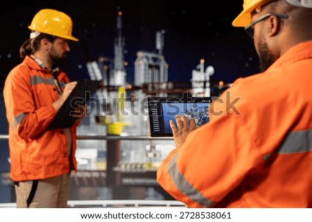 Drilling rig expert analyzing derrick performance on tablet dashboard screen. Offshore platform worker monitoring oil extraction rates and system pressure using device app