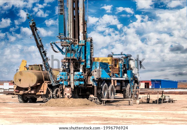Drilling rig\
in a field under a blue cloudy sky. Drilling deep wells. Geological\
exploration. Mineral\
exploration