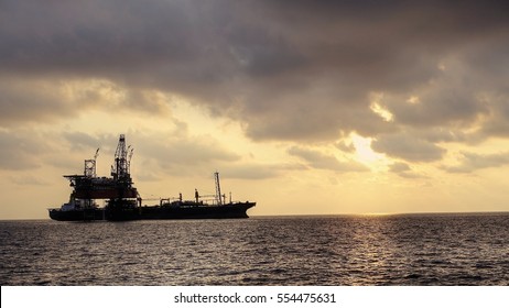 Drilling Rig With FPSO Ship At Site In The Evening Golden Hours.