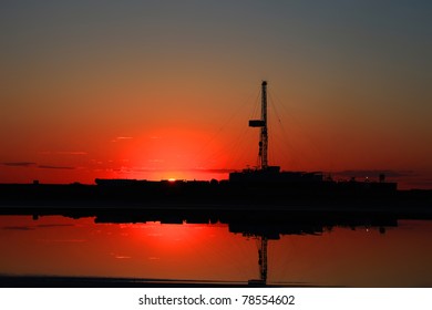 Drilling Rig Is On Sunset In Kazakhstan Oil Field.