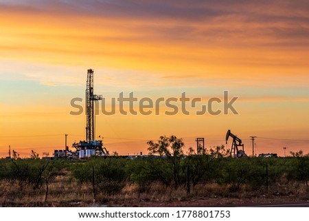 Drilling rig and pump jack sunset