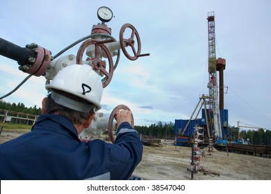 A drilling rig worker. Focus is on the instruments.