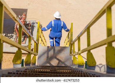 A Drilling Rig Worker Walking Down The Stair Case