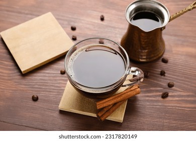 Drink coasters with cup of coffee, cinnamon and jezve on wooden table
