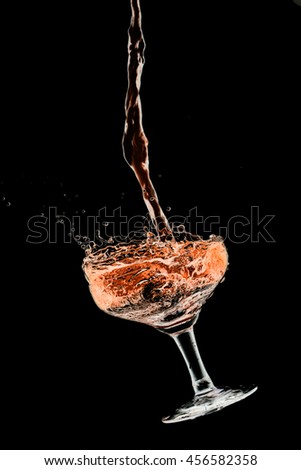 Drink cocktail glass splash out on a black background.