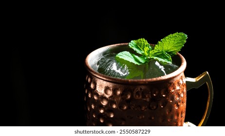 A drink in a copper mug with ice cubes and fresh mint leaves on a black background - Powered by Shutterstock