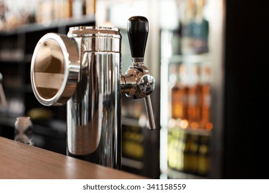 drink, equipment and object concept - close up of single tap chrome draft beer kegerator tower at bar or pub