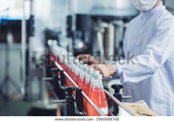 Drink factory - closeup hygiene\
worker working check juice glass bottled in production line\
