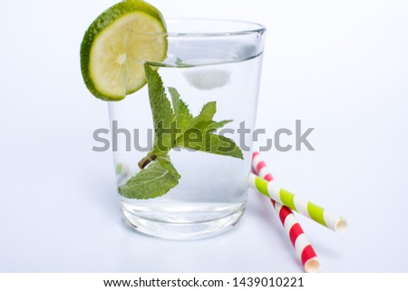 Drink with ice, lime  and mint served with paper straw