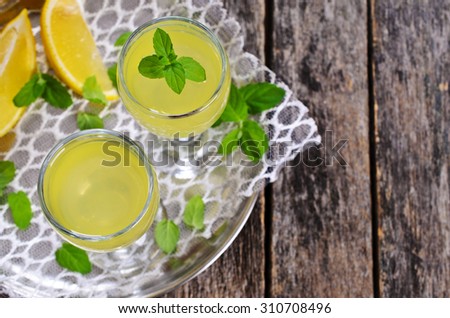 Drink of lemon in a small glass on a wooden surface