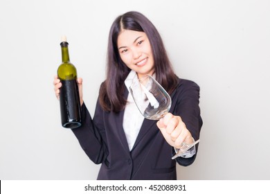 Drink it with me, Professional young asian woman wear black suit holding a bottle of wine on white background