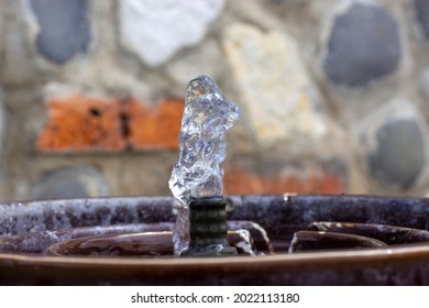 Drink Water Fountain Outdoor In A Park. Water Streaming From Metallic Drinking Fountain. Old Beautiful Stone Wall On Background. Nobody. No People. Concept Image.