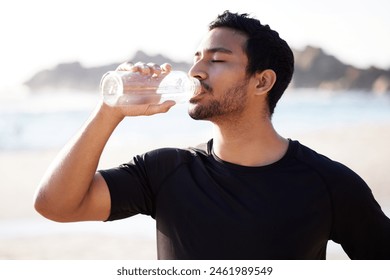 Drink, water and man at beach with fitness from exercise or workout in summer with hydration. Healthy, athlete and person training with liquid in bottle for benefits to wellness and energy at sea - Powered by Shutterstock