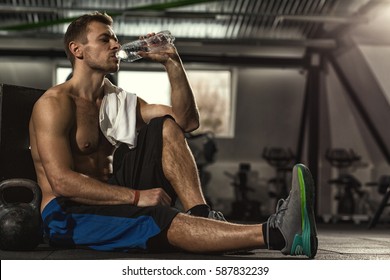 Drink water. Shirtless sportsman resting after training at the gym sitting on the floor drinking water with his eyes closed copyspase pleasure resting relax sports water lifestyle hydration vitality - Powered by Shutterstock