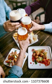 Drinking Beer. Friends Raising Glasses Of Beer