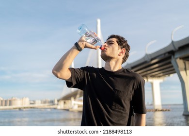 Drinking Clean Water From A Bottle Quenches Thirst, A Male Athlete Runner Does A Workout.