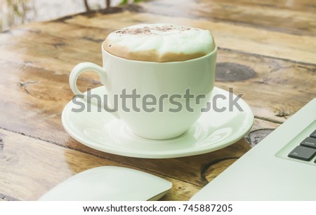 Drinking coffee and using laptop