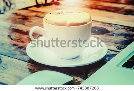 Drinking coffee and using laptop