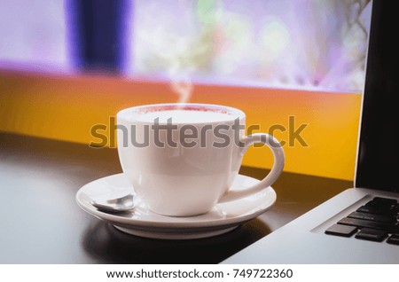Drinking coffee and using laptop