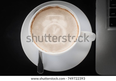 Drinking coffee and using laptop