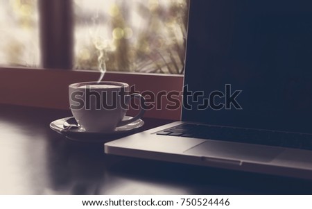 Drinking coffee and using laptop