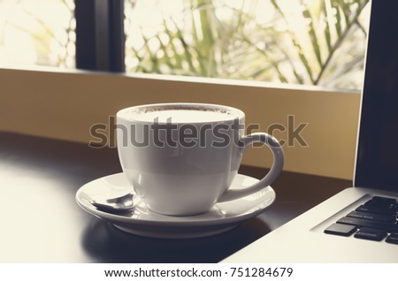 Drinking coffee and using laptop
