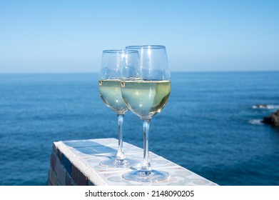 Drinking of cold verdejo white wine with view on blue Atlantic ocean on Tenerife, Canary islands, Spain