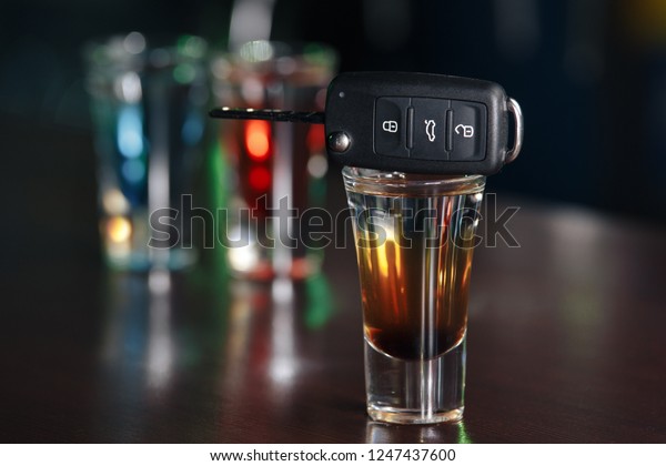 Drinking and driving concept. Car key on a wooden
table, pub