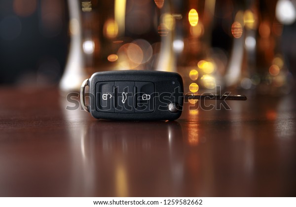 Drinking and driving concept. Car key on a wooden\
table, pub