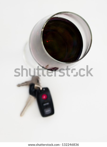 Drinking and driving. Wine glass and car keys\
on white background.