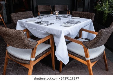 Drinking glasses and table setting on table. Interior of a summer terrace of restaurant. Table and chairs in empty cafe. Outdoor empty coffee and restaurant terrace. Street photo, nobody - Powered by Shutterstock