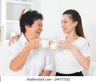 Drinking Milk. Asian Family Drinking Milk At Home. Beautiful Senior Mother And Adult Daughter, Healthcare Concept.