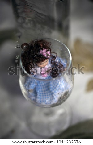 drinking - strange doll in blue dress in a glass
