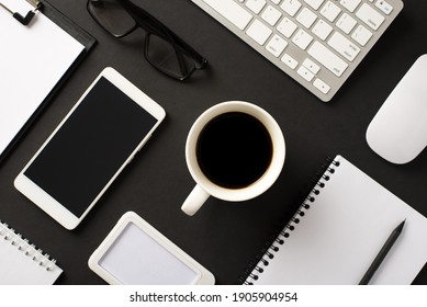 Drinking strong coffee in morning before work concept. Top overhead above flat lay view photo of office set accessories keyboard cell phone organizer eyeglasses isolated black color contrast backdrop