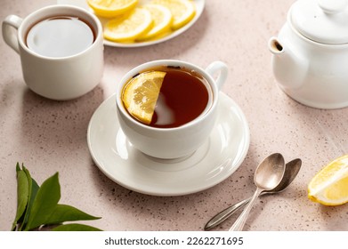 Drinking tea, white ceramic cup of black tea and lemon slice. Slow living. 