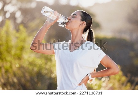 Drinking water, fitness and exercise woman after sports run and training in nature. Workout, hiking and walking challenge with a bottle of a female runner in summer ready for running for health