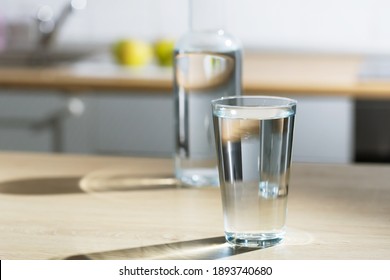 Drinking Water Is Poured Into A Glass In A Kitchen Table