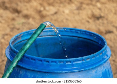 Drinking Water Pours From A Hose Into A Barrel. The Concept Of Drinking Water Shortage.