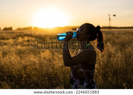 drinking water with a reusable bottle in natureoutdoors