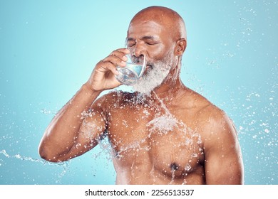 Drinking water, splash and skincare of black man in studio isolated on blue background. Wellness, cleaning and senior male model drink liquid for hydration, bathing and washing for health and hygiene - Powered by Shutterstock